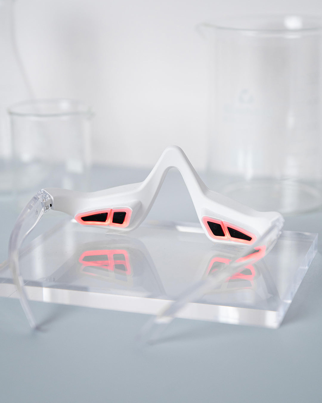 Clear plastic visor with pink interior on a reflective surface